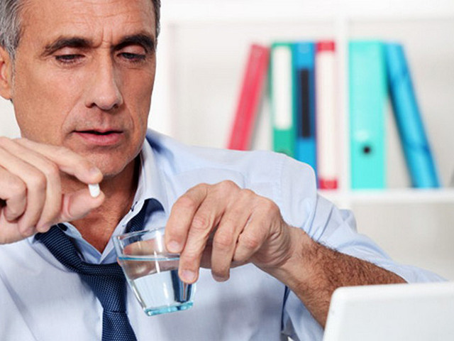 Человек пьет таблетку 